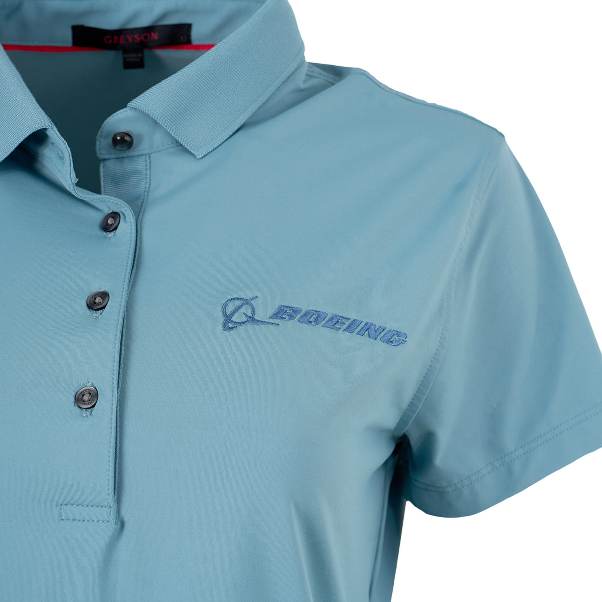A close-up of the Greyson Boeing Women’s Scarlett Crowley Polo, a light blue performance shirt with a knit cutaway collar and buttons, featuring the BOEING logo and name embroidered on the left chest.