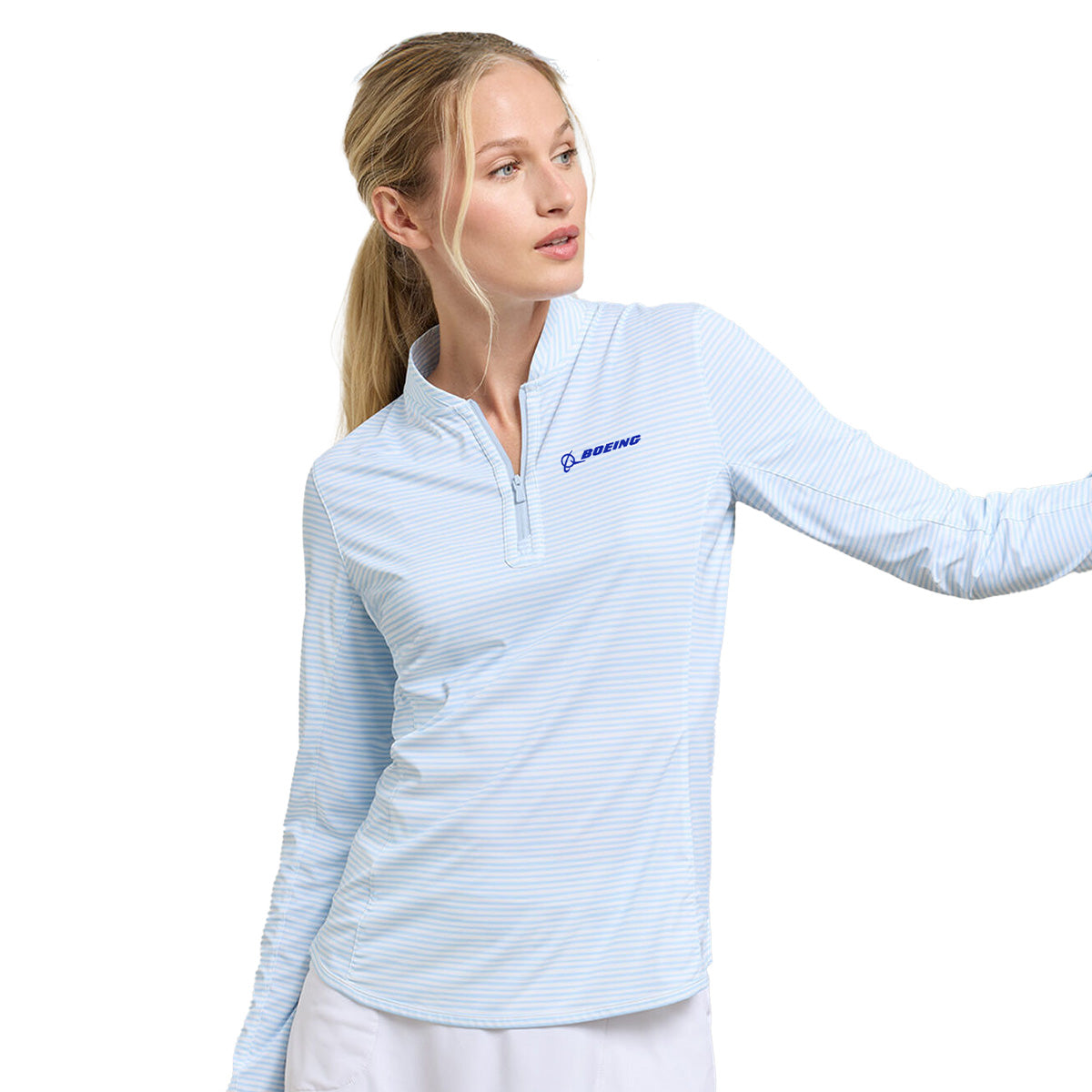 A woman wears the Peter Millar Boeing Women’s Lightweight Sun Shirt in light blue with subtle stripes and a Boeing logo on the chest, looking left with one arm slightly raised. Brand: BOEING.