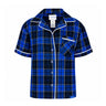 A blue and black Boeing 2026 Jet Snowflake Women’s Flannel Pajama Top featuring short sleeves, white piping, a button-down front, and a single angled chest pocket.