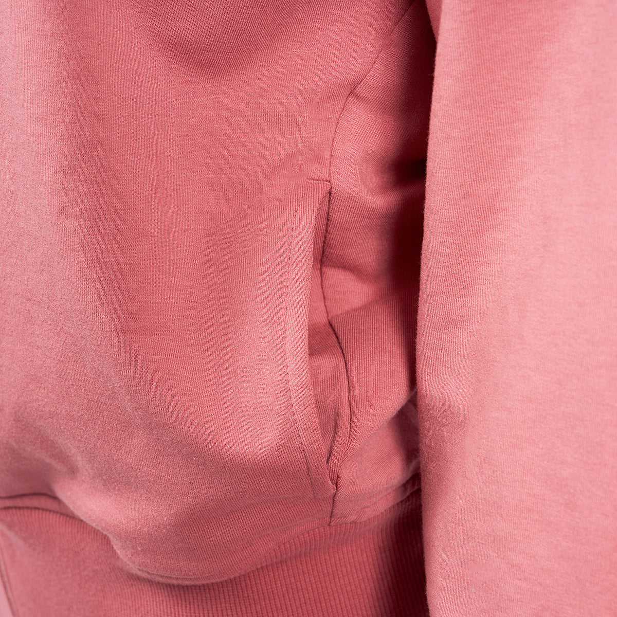 Close-up of a pink Boeing Signature Logo Womens Short Waist Hoodie by The Boeing Store shows its side pocket. The visible soft material texture highlights its cozy feel, while the YKK zipper and stitching detail enhance the garments quality and style.