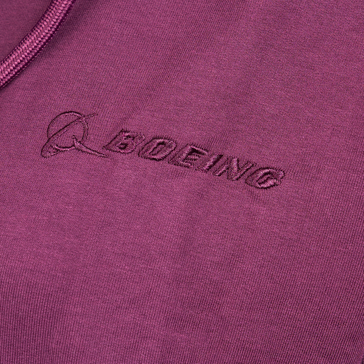 Close-up of a maroon Boeing Signature Logo Womens Short Waist Hoodie by The Boeing Store, featuring the embroidered Boeing logo and name.