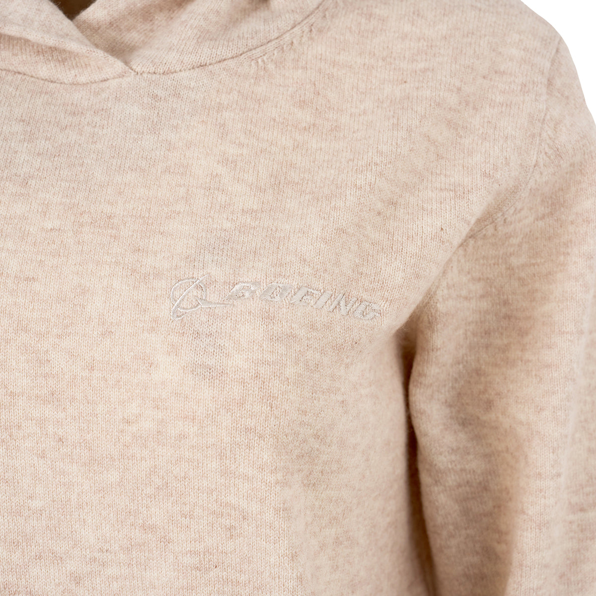 Close-up of the Greyson Boeing Women’s Classic Koko Hoodie, a beige fleece sweatshirt with a subtle embroidered white Boeing logo on the chest and a modern boxy silhouette.