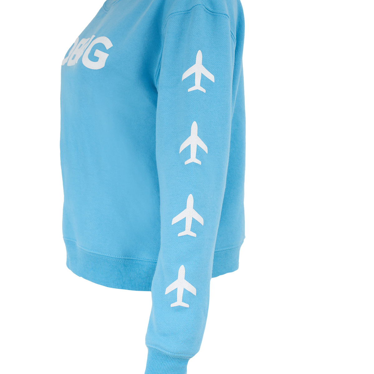 A woman wears a BOEING Women's Crewneck Sweatshirt in light blue cotton-polyester fleece, with white airplane icons down the sleeve and bold white lettering on the chest.