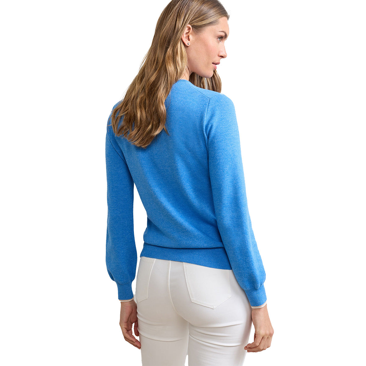 A woman with long, wavy light brown hair is shown from the back, wearing a BOEING Peter Millar Boeing Women’s Coolspun Lite Cotton Crewneck in bright blue and fitted white pants against a plain white background.