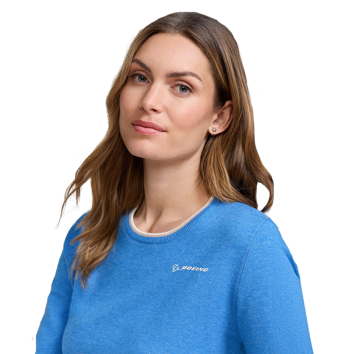 A woman with long brown hair wears a Peter Millar Boeing Women’s Coolspun Lite Cotton Crewneck sweater, blue in color, featuring the BOEING logo. She stands against a white background, looking at the camera with a neutral expression.