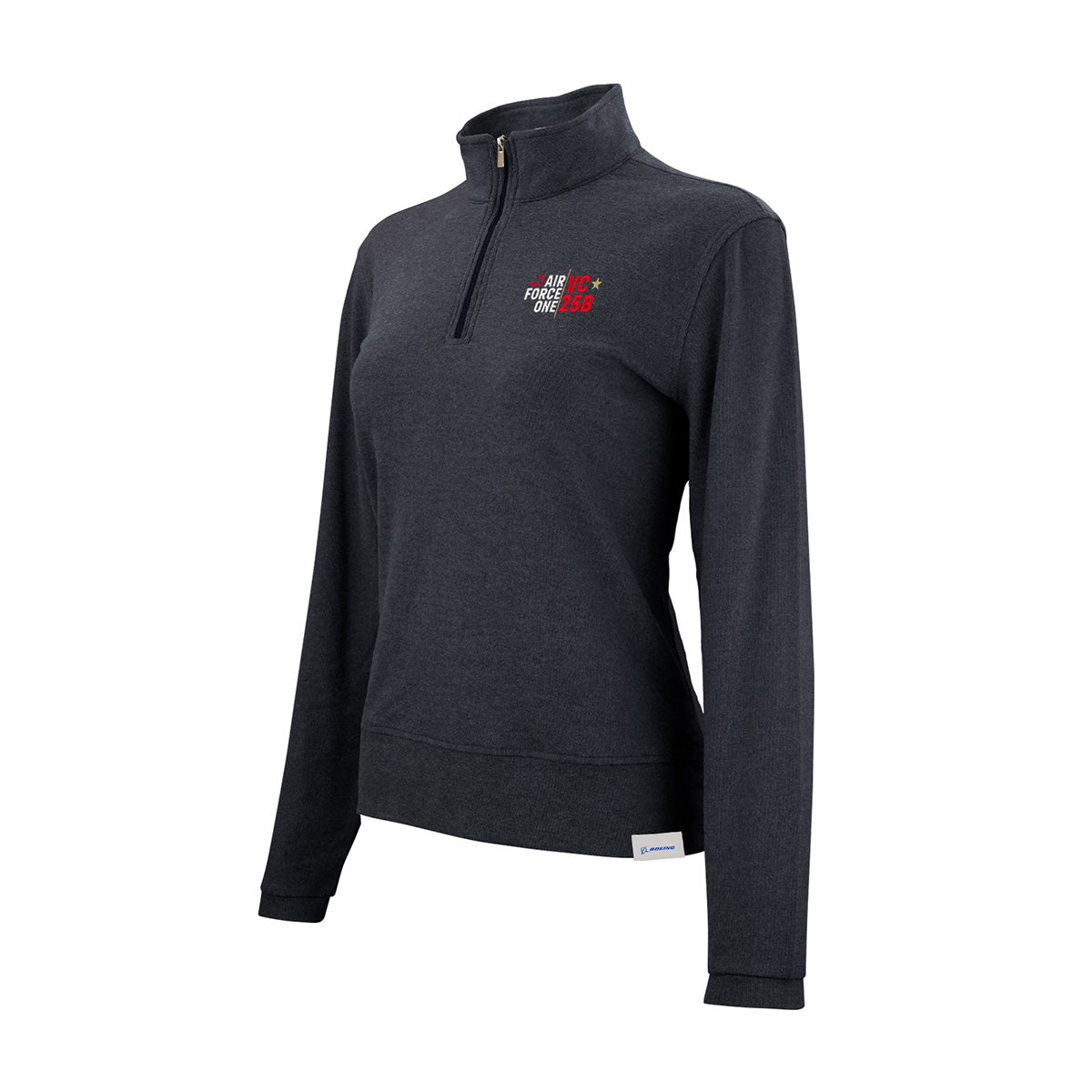 Introducing the Boeing VC-25B Women’s Luxe Quarter-Zip by BOEING—a dark gray pullover designed with long sleeves, a stand-up collar, and crafted from moisture-wicking fabric. This comfortable piece showcases a small embroidered VC-25B logo on the left chest and is finished with a subtle white tag at the hem, blending comfort with Boeing’s signature style.