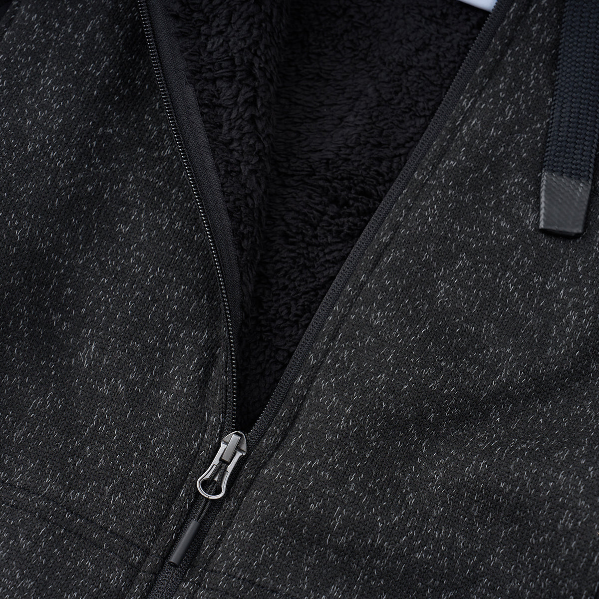 Close-up of the Boeing Women's Mountain Fleece Jacket by BOEING in charcoal gray, featuring power stretch panels, a soft black fleece lining, a partially open zipper, and a visible drawstring at the top right.