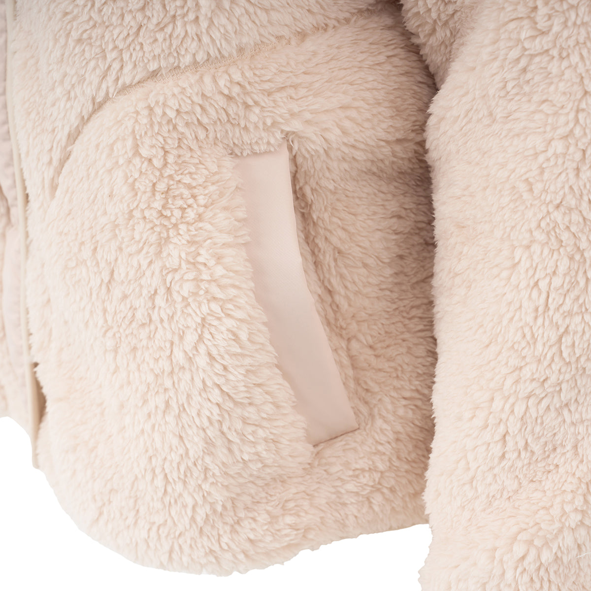 Close-up of the BOEING Women's Sierra Sherpa Long Jacket in light beige, featuring a side pocket with matching trim. The soft, textured fleece material emphasizes the jacket’s lightweight, cozy, and warm look.