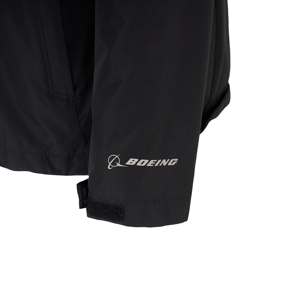 Close-up of the black Boeing Women's 3-in-1 Systems Jacket sleeve, featuring the BOEING logo and a small planet graphic in white near the cuff, plus an adjustable Velcro strap for a secure fit.