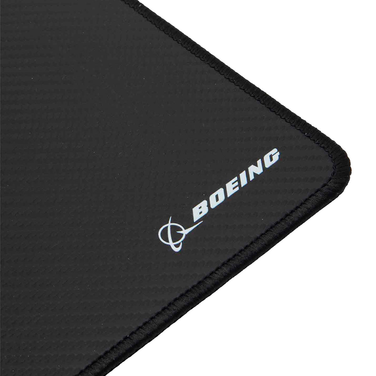 A close-up of the corner of the Boeing Signature Carbon Fiber Mouse Pad by BOEING, featuring its black rectangular shape and textured surface with the BOEING logo and name printed in white.