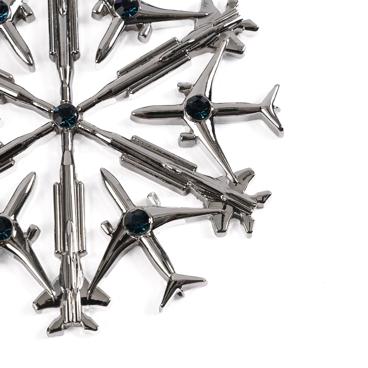 Introducing the Boeing 2024 Jet Snowflake Ornament: a design featuring metallic airplanes and rockets, with elements inspired by the 787 Dreamliner and F-15EX Eagle. It is centered with a dark blue gem on a pristine white background.