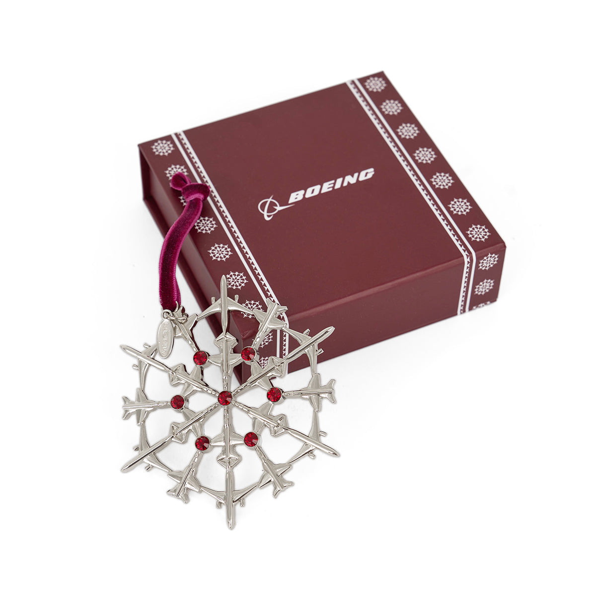The Boeing 2025 Jet Snowflake Ornament by BOEING, made from miniature airplane figures with red accents, is displayed before a maroon box with a white Boeing logo—an ideal holiday gift for any aviation fan.