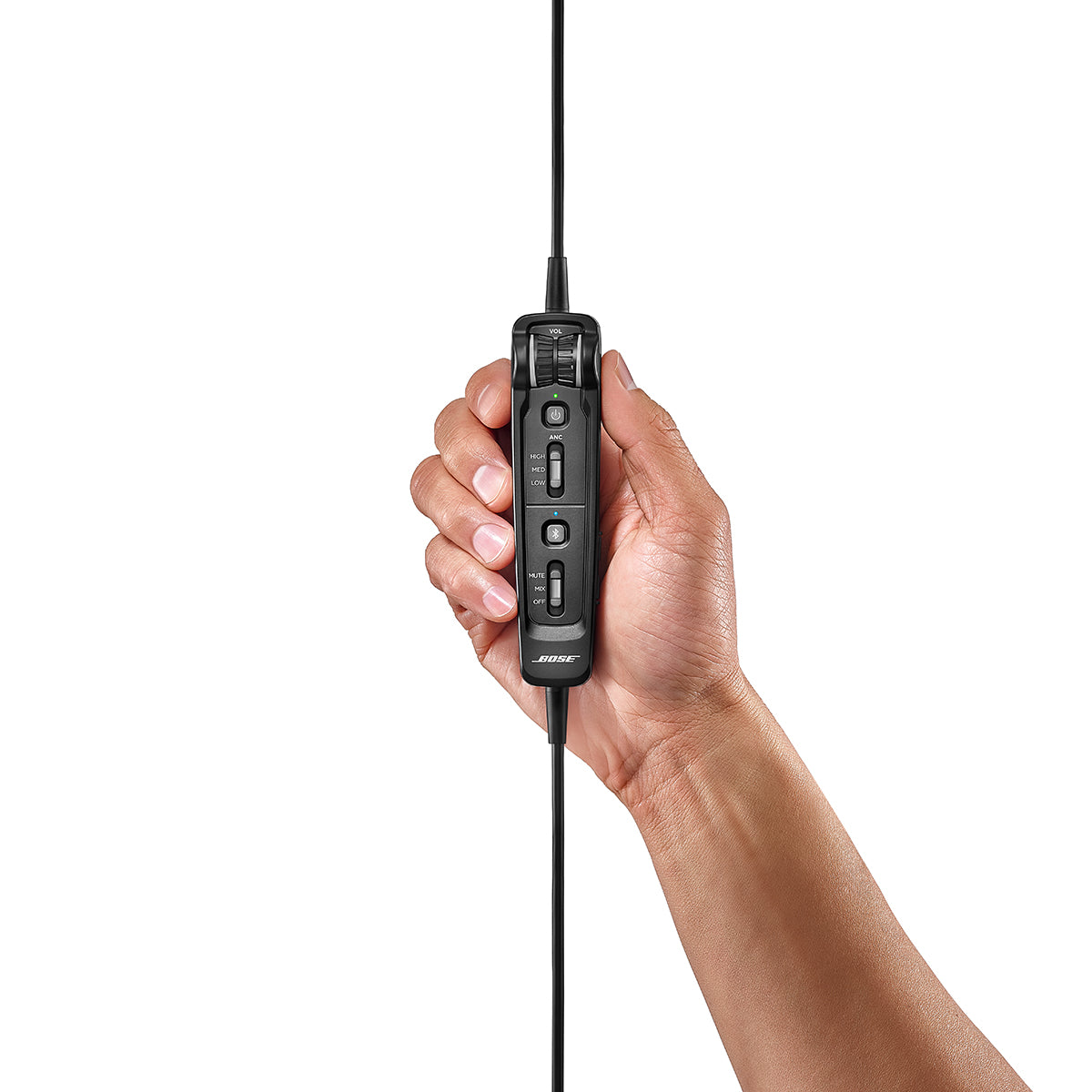 A hand holds the sleek inline remote control, embossed with the BOSE logo, designed for the Bose A30 Aviation Headset with Bluetooth. Essential for aviators, it features buttons for active noise cancellation and is showcased against a pristine white background.