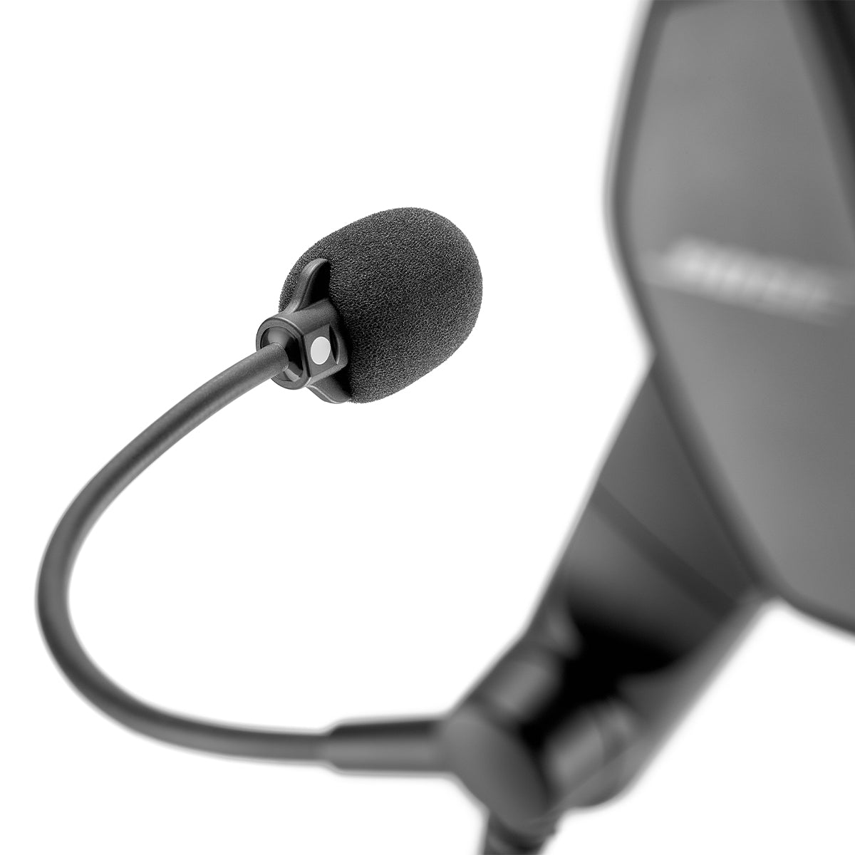 Close-up of a BOSE ProFlight Series 2 Aviation Headset with Bluetooth showcasing a black microphone with foam windscreen on an extended arm. The sleek design, blurred background, and active noise cancellation highlight its modern aesthetics.
