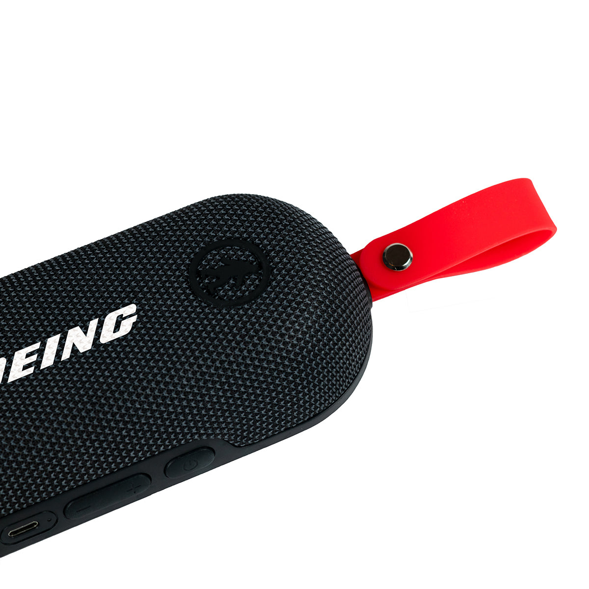 The Outdoor Tech Boeing Bolt Wireless Speaker by BOEING is a black, portable, waterproof Bluetooth speaker with a textured surface, a partial BOEING logo, and a red silicone carrying strap for hands-free use on the go.
