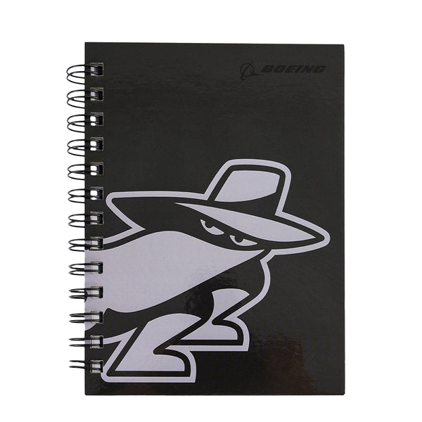 The Boeing Phantom Works 2025 Notebook is a black spiral notebook from BOEING, featuring a cartoon in a hat and trench coat on the cover and highlighting Boeing Phantom Works’ link to advanced aerospace technology.