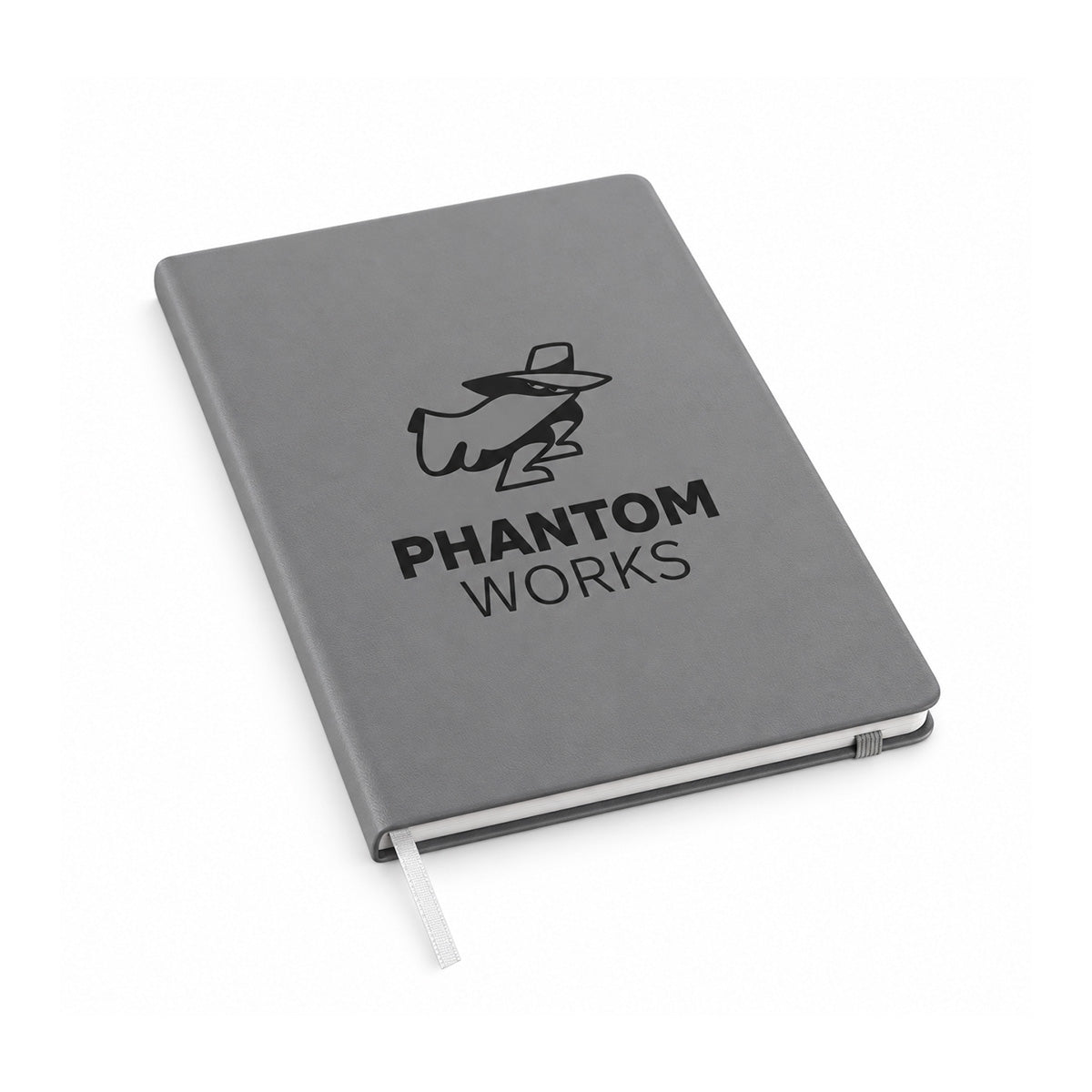 The Boeing Phantom Works Leather Bound Notebook by BOEING is shown closed against a white background. This gray premium notebook features a black logo of a figure in a hat and mask above the text “PHANTOM WORKS,” includes 70GSM paper, and comes with a white ribbon bookmark.