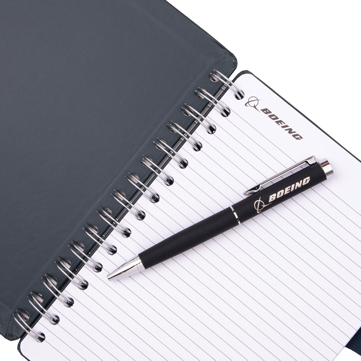 A Boeing C-17 Globemaster Graphic Notebook Pen Set featuring an open, spiral-bound notebook with lined paper next to a black ballpoint pen, both branded with a C-17 Globemaster logo.