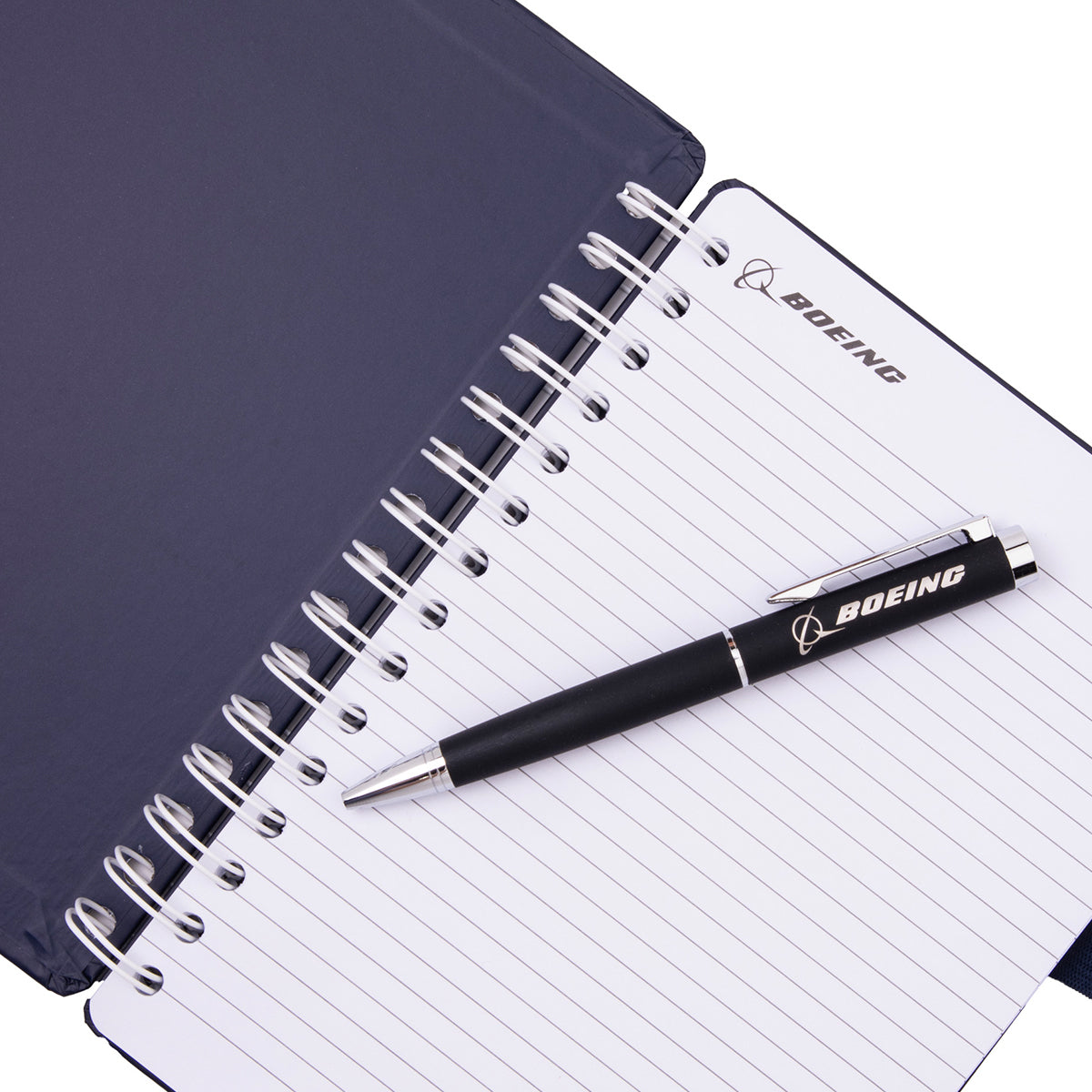 A spiral-bound Boeing F-15EX Eagle Graphic Notebook Pen Set with lined pages and a matching black ballpoint pen resting on top, both featuring a logo.