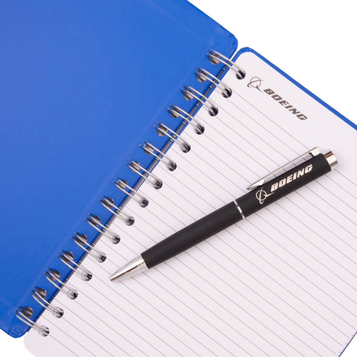A blue spiral-bound Boeing F/A-18 Super Hornet Graphic Notebook Pen Set with lined pages and a black pen resting on top.