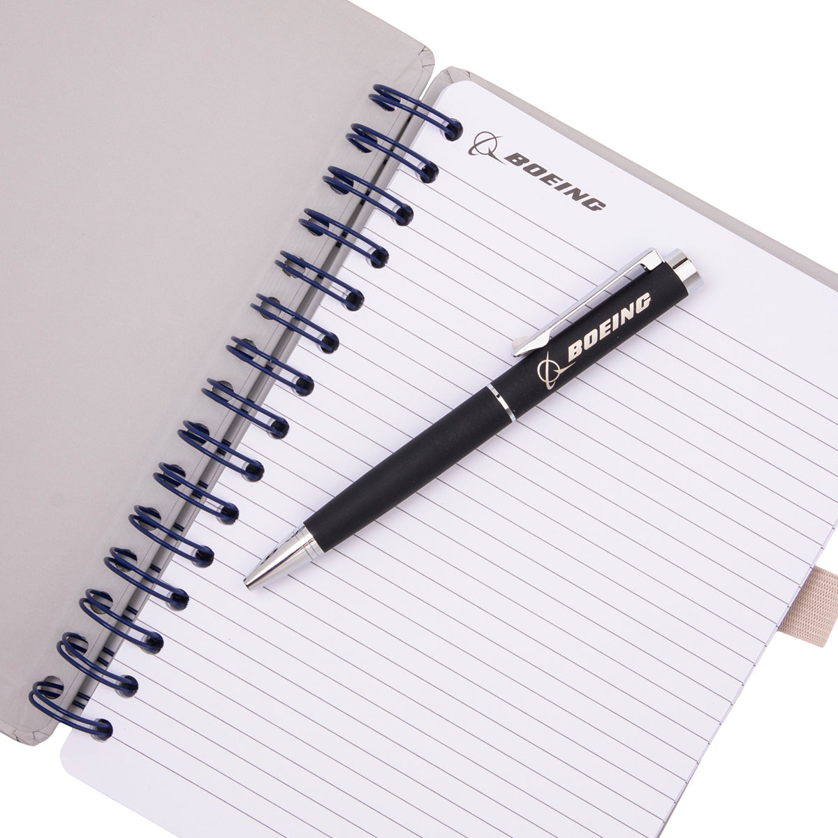 Boeing P-8 Poseidon Graphic Notebook Pen Set featuring a spiral-bound notebook with lined paper and a black ballpoint pen resting on top, both branded with a P-8 Poseidon aviation logo.