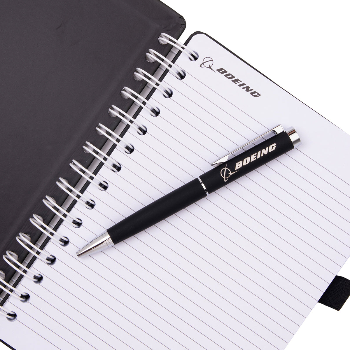 A Boeing X-37B Orbital Test Vehicle Graphic Notebook Pen Set featuring a spiral-bound notebook with lined pages and a black retractable ballpoint pen resting on top.