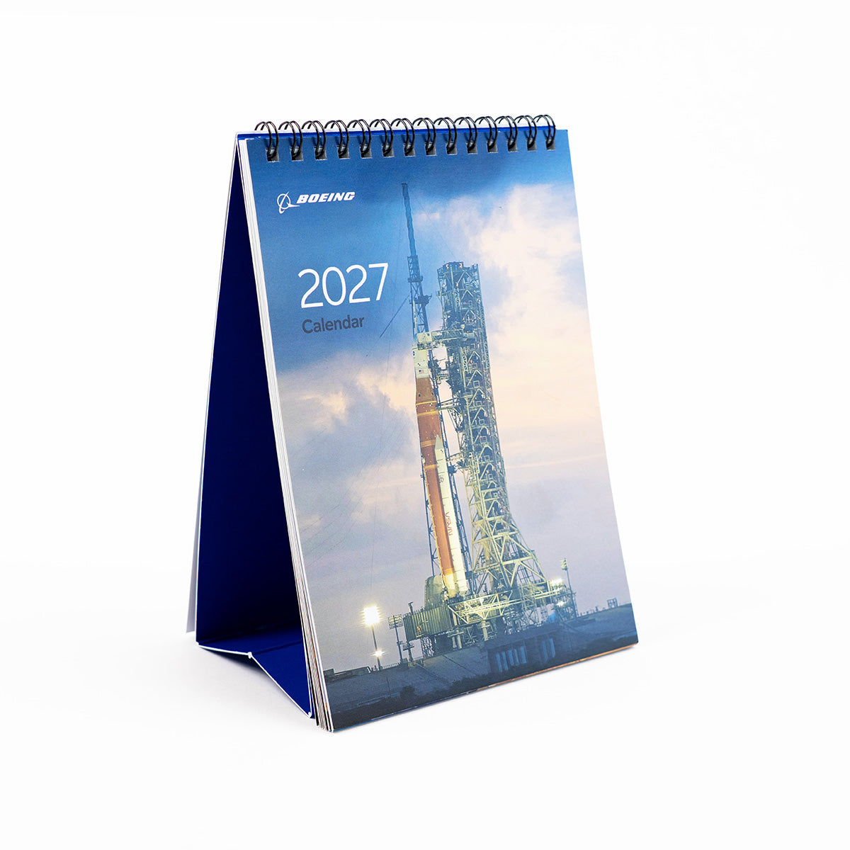 The Boeing 2027 Desktop Calendar by BOEING is a standing spiral-bound calendar featuring a striking cover image of a rocket on the launch pad at sunset—an ideal addition for aerospace enthusiasts.