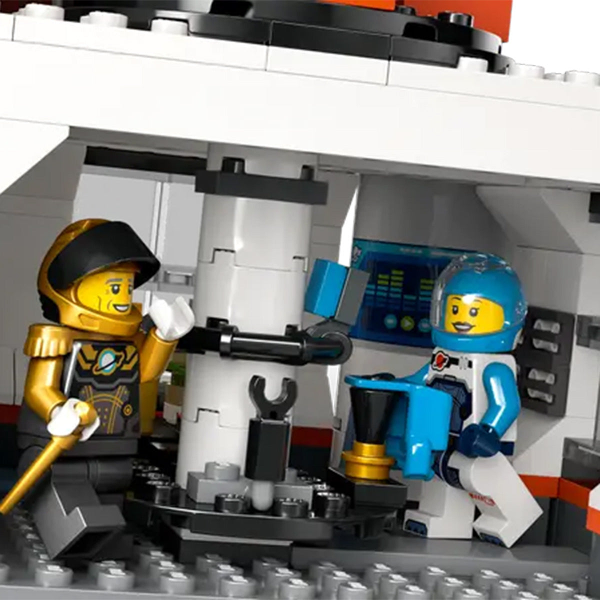 Two LEGO Space Base and Rocket minifigures—one in a gold and black suit, the other in blue and white—interact inside a detailed spaceship interior with control panels, perfect for imaginative space exploration adventures.