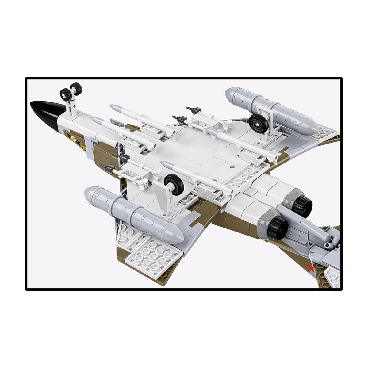 The COBI F-4M Phantom II by BOEING is a military jet model inspired by British aviation, featuring twin engines, missile attachments, and a white and tan color scheme, shown from below.