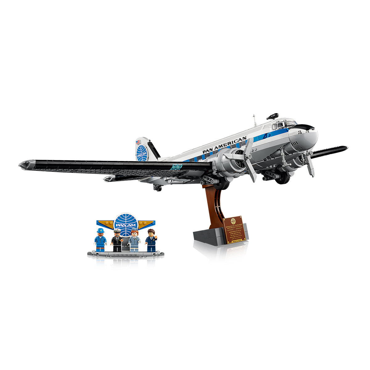 The LEGO® Boeing Douglas DC-3 PAN AM Airliner by BOEING includes a display stand, a Pan Am sign, and four uniformed minifigures arranged next to the iconic model kit on a white background.