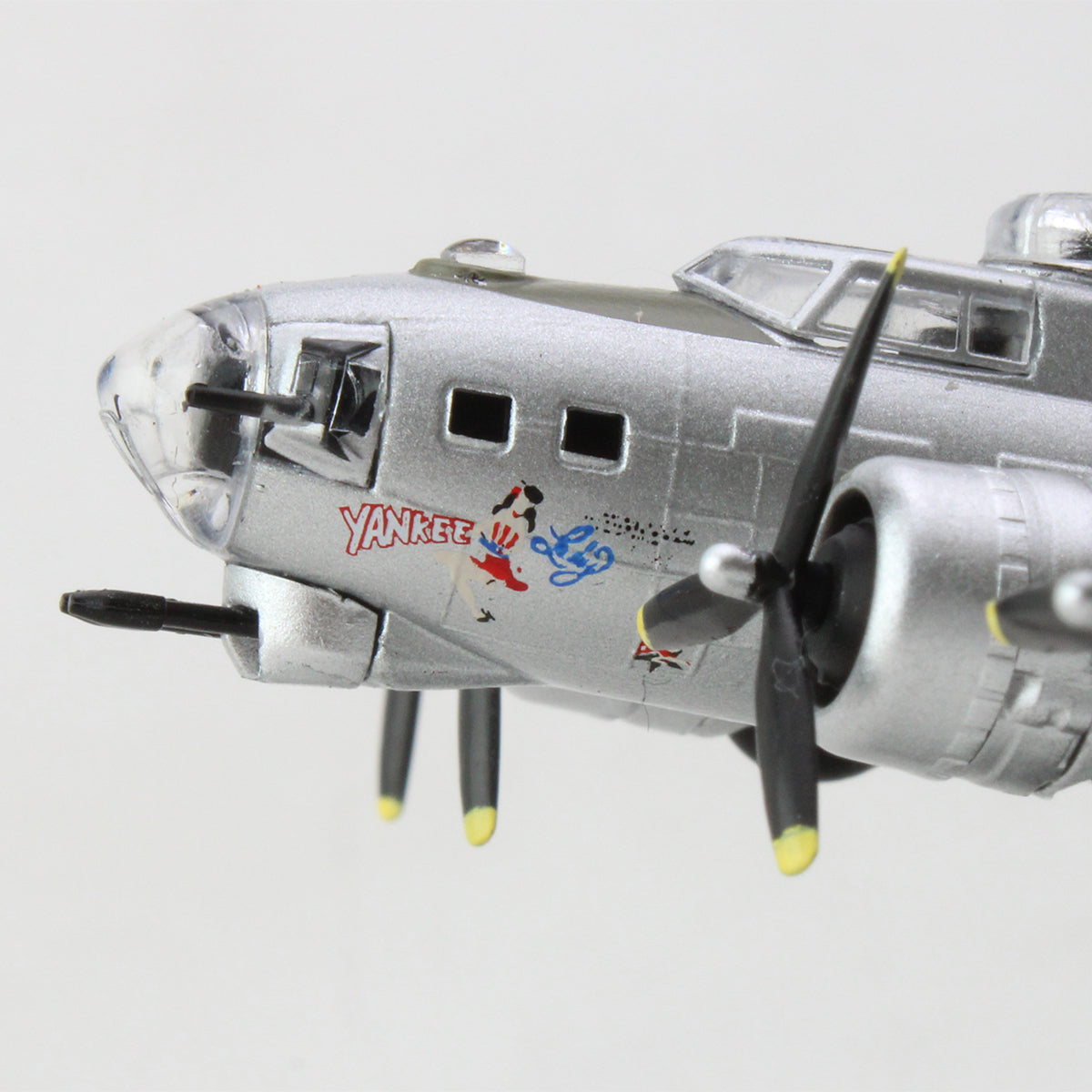 Close-up of the DARON Boeing B-17G Flying Fortress Yankee Lady Diecast Model, featuring iconic nose art with a cartoon woman and blue figure. Visible propeller and cockpit windows make it a must-have for aviation collectors.