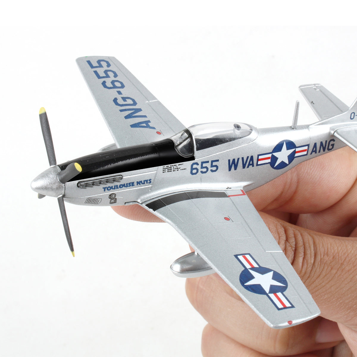 A hand holds the DARON Boeing P-51D Mustang Toulouse Nuts Diecast Model, featuring U.S. Air Force markings, a blue star insignia, code ANG-655, and a black propeller with yellow tips—capturing classic WWII fighter style.