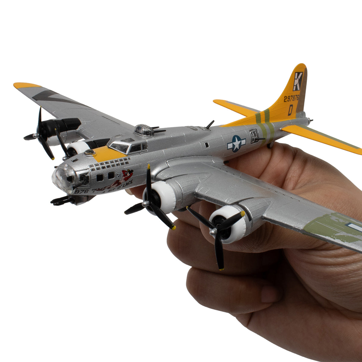 A hand holds the DARON Boeing B-17G Flying Fortress "A Bit O'Lace" diecast model, a 1:155 scale WWII bomber with a silver body, yellow tail, black propellers, and U.S. Air Force insignia.
