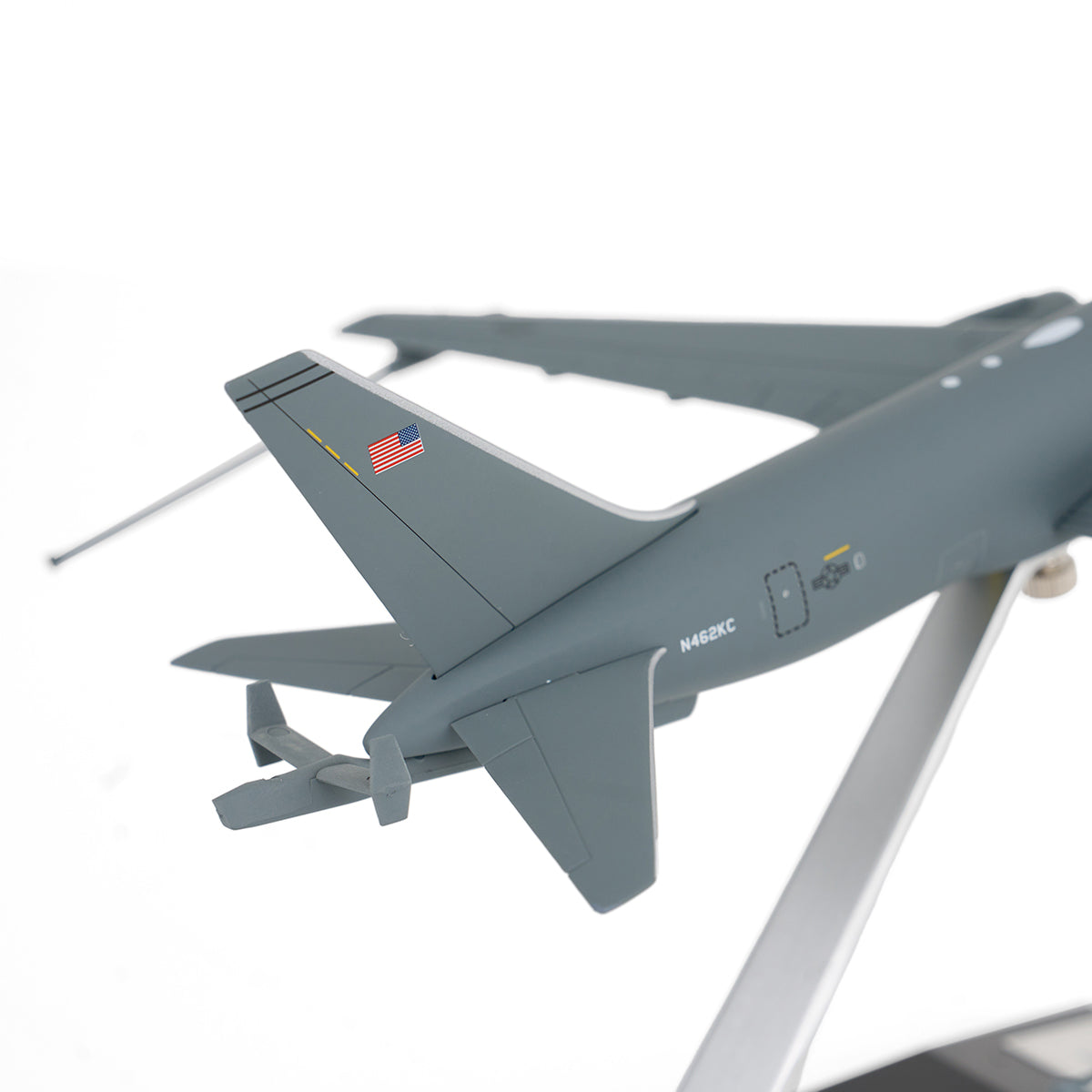 A close-up of the DARON Boeing KC-46A Pegasus 1:200 Model tail features the American flag, ID markings, and part of the wing on a metal stand—ideal for collectors—set against a white background.
