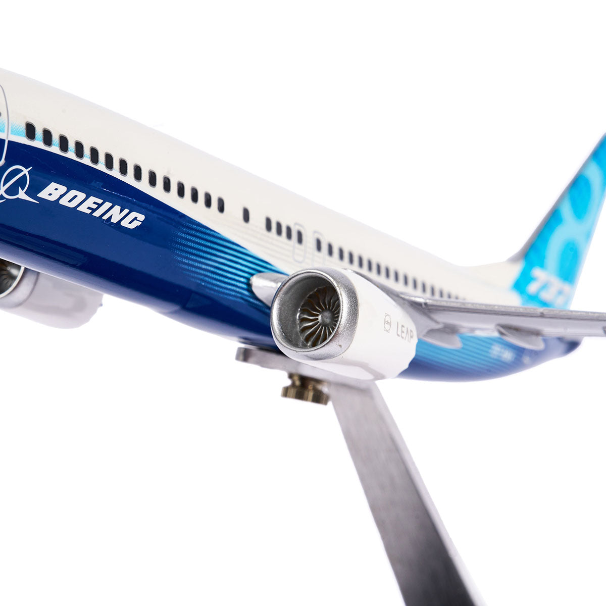 The Boeing Unified 737 MAX 8 model by Pacific Miniatures features intricate engine detail, crafted from precision injection-molded plastic in blue and white with a logo on a metal stand, highlighting its fuel efficiency.
