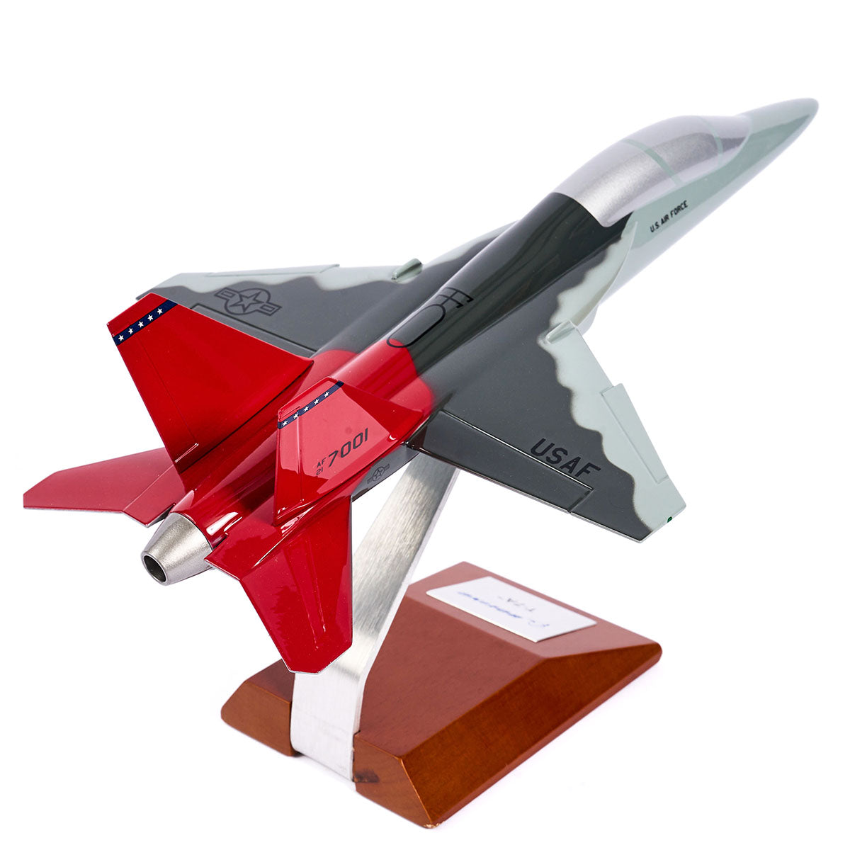 The Boeing Stores Boeing T-7A Red Hawk 1:48 Model features a gray body, red tail, wooden stand with metal support, high-quality silk screen details, USAF insignia, and honors the Tuskegee Airmen legacy.