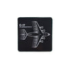 The Boeing Stores Boeing C-17 Globemaster Motion Magnet is a black square sign with an enamel depiction of the C-17 aircraft from above. Ideal for aviation fans, it features the text C-17 Globemaster III in white on the left side.
