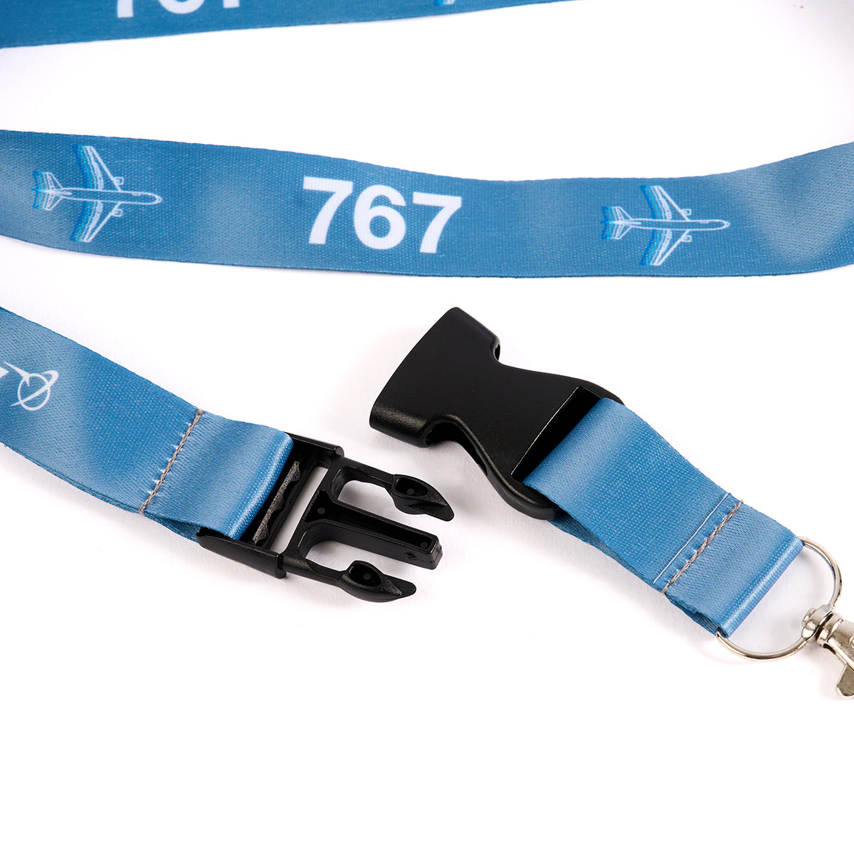 The Boeing Stores Boeing 767 Motion Lanyard is aviation-inspired, adorned with a 767 sublimation print and airplane illustrations. It features a black plastic buckle clip and metal swivel hook, ideal for aviation enthusiasts.