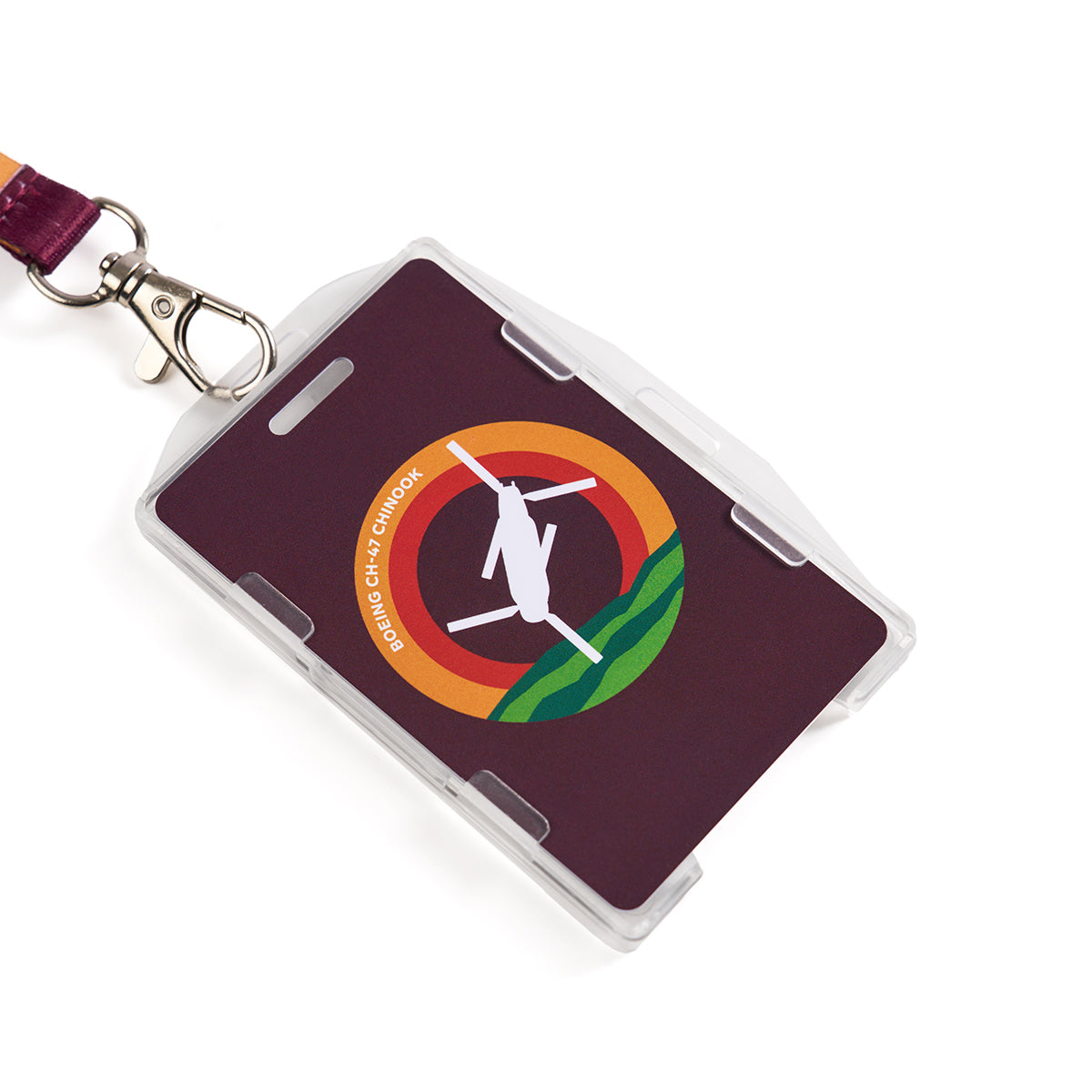 The Boeing CH-47 Chinook Skyward Lanyard features a rectangular ID badge in a clear plastic holder with sublimation print of a helicopter and red/orange semi-circles. The text reads: Boeing CH-47 Chinook. It hangs from a maroon lanyard for easy wearing.