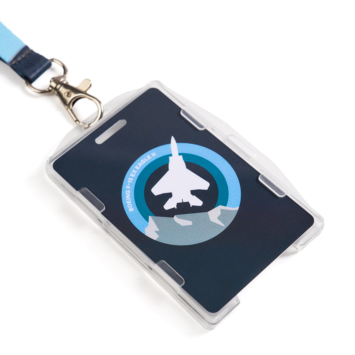 A Boeing F-15EX Eagle Skyward Lanyard with a clip attached to a badge holder featuring a sublimation print of a jet silhouette encircled by blue rings and the text Boeing F-15E Eagle II.