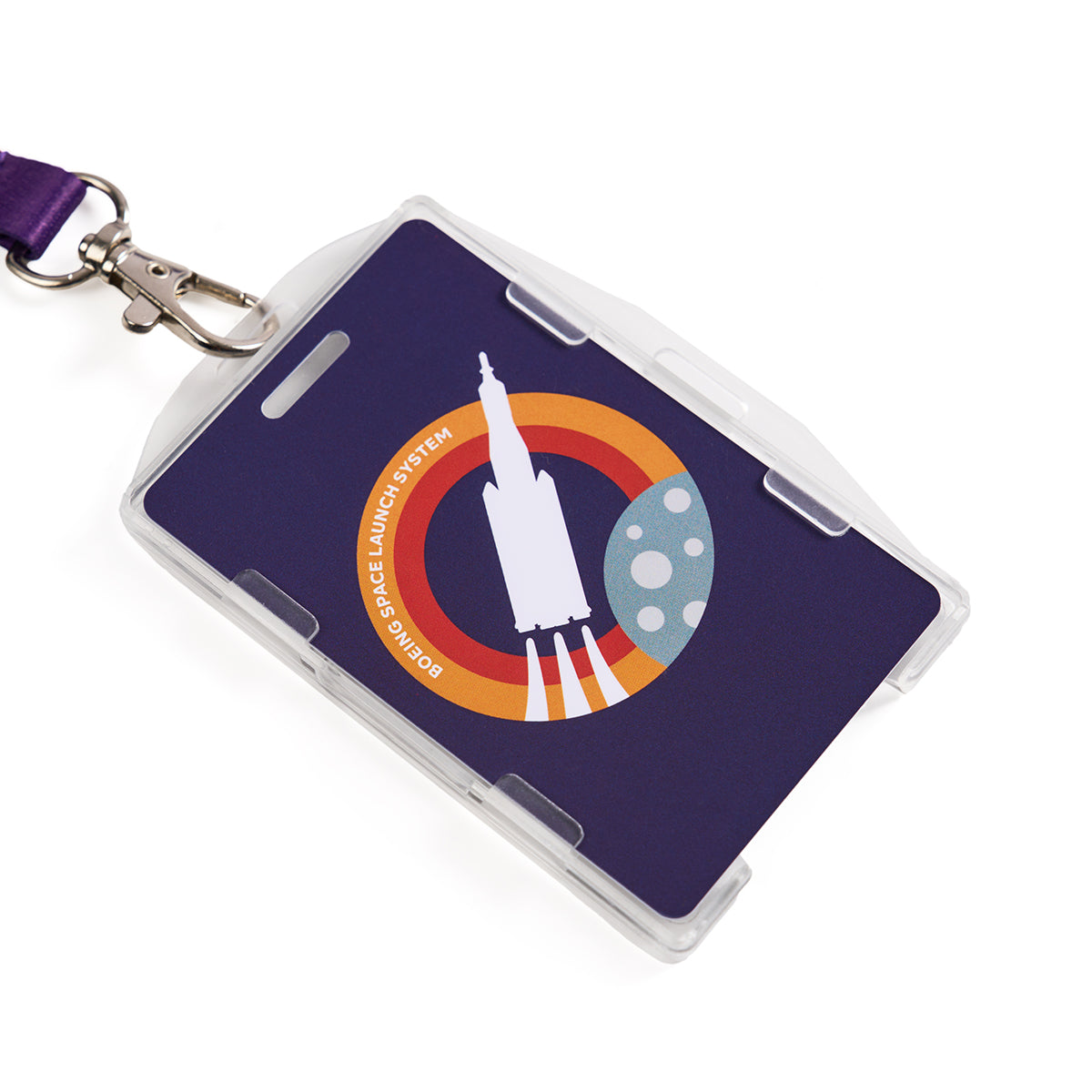 The Boeing Space Launch System Skyward Lanyard features a purple strap with a sublimated rocket graphic launching against a red and orange circular backdrop, resembling a planet, and the text EM-1 Demo Space Launch System.