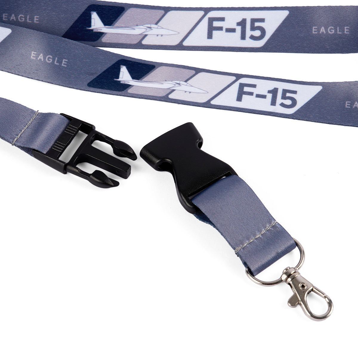 The Boeing F-15 Eagle Velocity Lanyard features a sublimation print with F-15 text and plane graphics, EAGLE text, a black plastic buckle, and a metal swivel hook, making it ideal for any Boeing F-15 enthusiast.