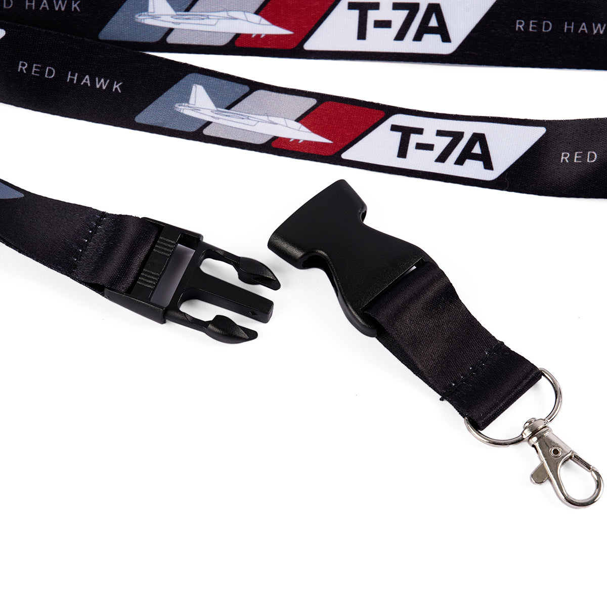 The Boeing T-7A Red Hawk Velocity Lanyard features bold Boeing T-7A Red Hawk text and an airplane graphic in vibrant print on a red and white background, complete with a durable black plastic buckle and a metallic swivel hook.