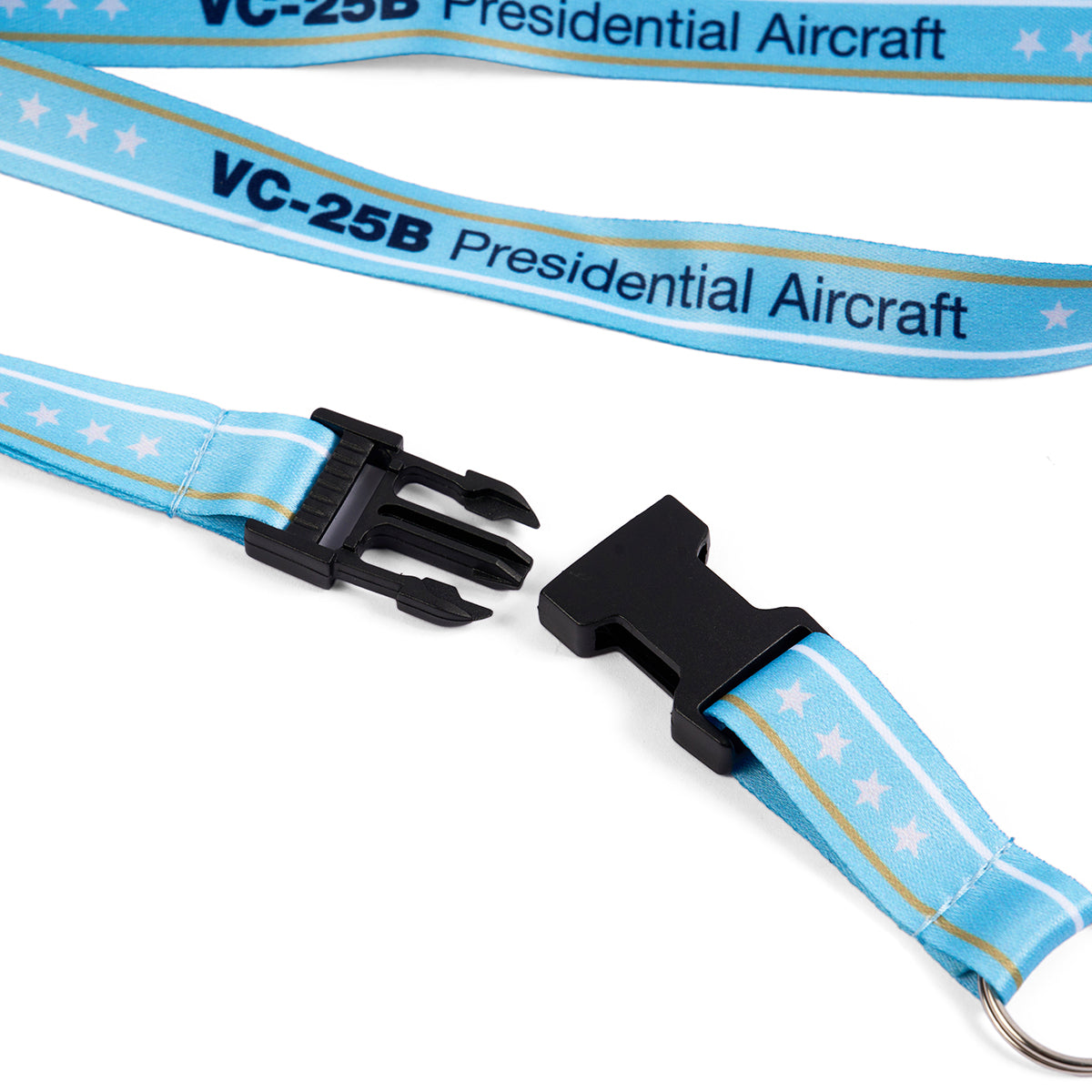 The Boeing VC-25B Lanyard from Boeing is a light blue polyester accessory featuring VC-25B Presidential Aircraft text and white stars. It includes a black plastic buckle, shown unfastened, and a metal key ring at one end, evoking the elegance of Boeing design.