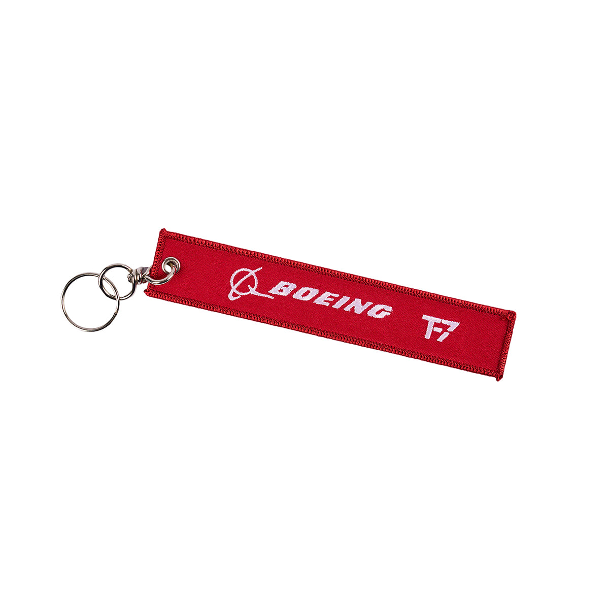The Boeing T-7A Remove Before Flight Keychain is a red fabric accessory with a metal ring, showcasing a white Boeing logo and Remove Before Flight design.