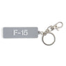 The BOEING F-15 Eagle Series Keychain features a rectangular gray design with white F-15 text, attached to a metal keyring and clasp—an ideal accessory for aviation enthusiasts.