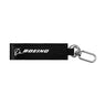 The BOEING Signature Strap Keychain is a black nylon keystrap with a silver carabiner and key ring, featuring the white Boeing logo and text on its surface.