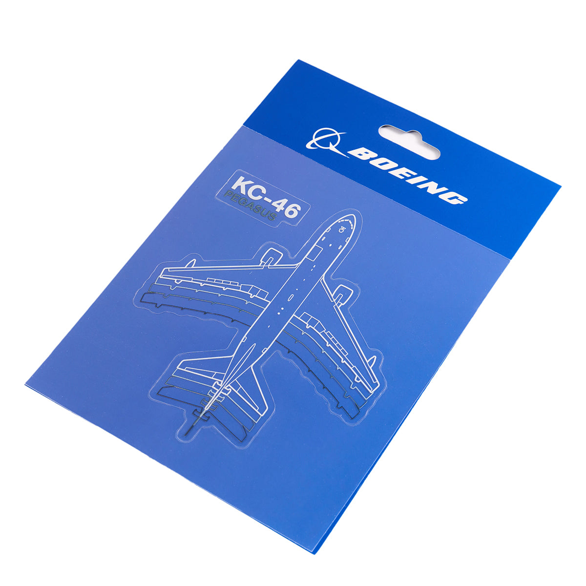 A blue package features a transparent waterproof vinyl sticker of a KC-46 Pegasus aircraft with white outlines. Boeing is printed above, and KC-46 is beside the sticker. The background lightens into a gradient at the bottom. Product: Boeing KC-46 Pegasus Motion Sticker, by The Boeing Store.