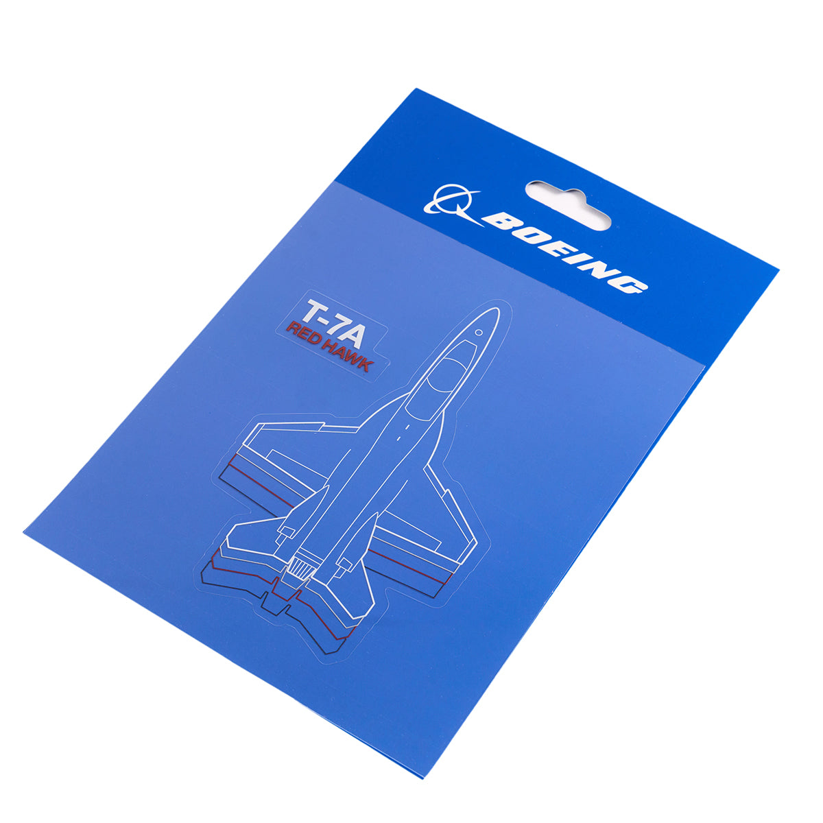 The Boeing Stores blue packaging for the T-7A Red Hawk Motion Sticker displays a blueprint-style illustration of the aircraft, prominently featuring white and red T-7A Red Hawk text and includes a complimentary sticker pack inside.