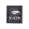 Boeing X-37B Orbital Test Vehicle Graphic Lapel Pin featuring a square illustration of the spacecraft against a dark, swirling background.